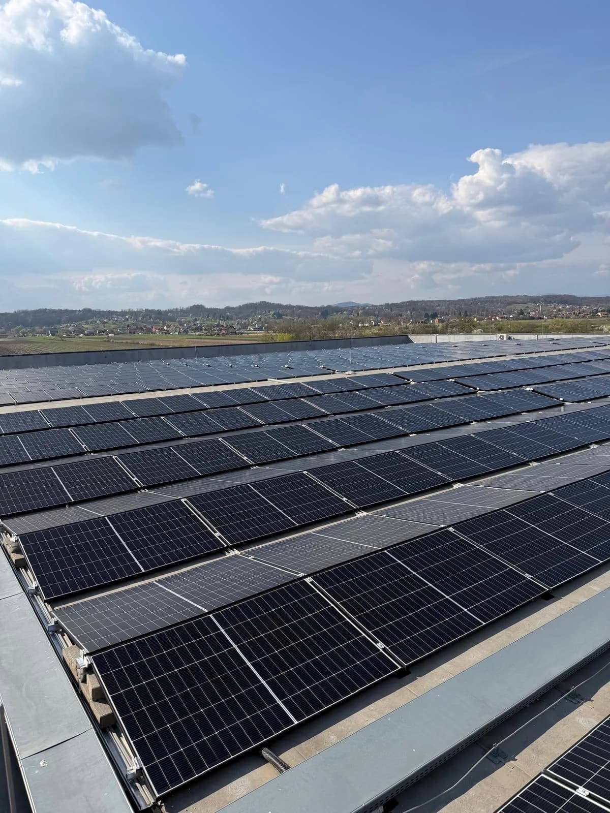 Veliki niz opranih solarnih panela na ravnom krovu poslovnog objekta